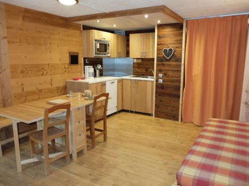 une cuisine avec une table en bois et une salle à manger dans l'établissement Studio rénové proche pistes, balcon, animaux acceptés - FR-1-502-478, à Tignes