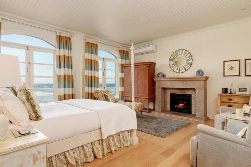 a bedroom with a bed and a fireplace at Buccara Pezula Castle in Knysna