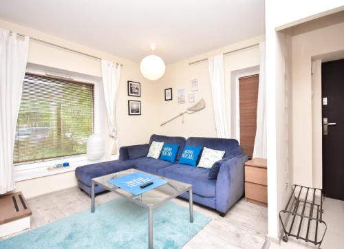 a living room with a blue couch and a table at Rent40 Sopot Łokietka 47D in Sopot