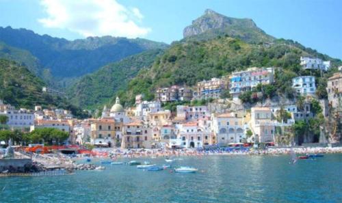 un gruppo di edifici e una spiaggia con barche in acqua di Intero appartamento nel cuore di Cetara a Cetara