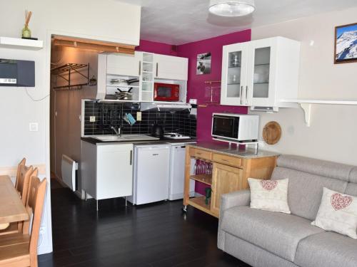une cuisine avec des armoires blanches et un canapé dans une pièce dans l'établissement Studio Sud avec Terrasse, Proche Centre et Téléphérique - FR-1-464-216, à Pralognan-la-Vanoise
