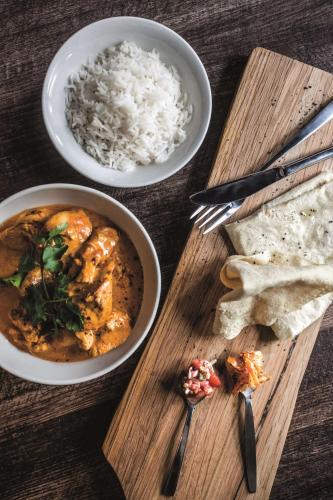 a table with two bowls of food and rice at Southern Sun Newlands in Cape Town