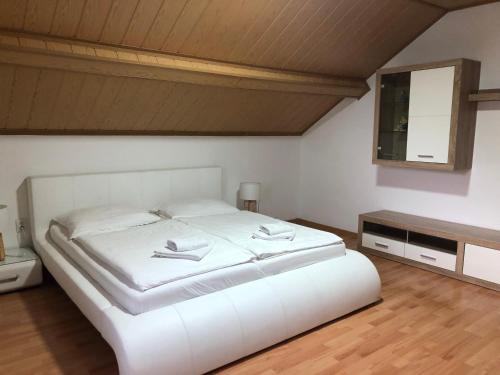a bedroom with a white bed and a mirror at Penzion Obora in Tachov