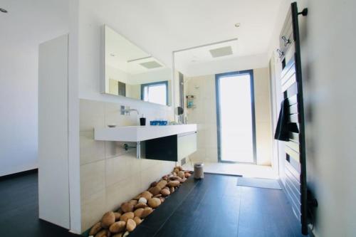uma casa de banho com um lavatório e um balcão com troncos no chão em Le Palais des Vignes em Estézargues