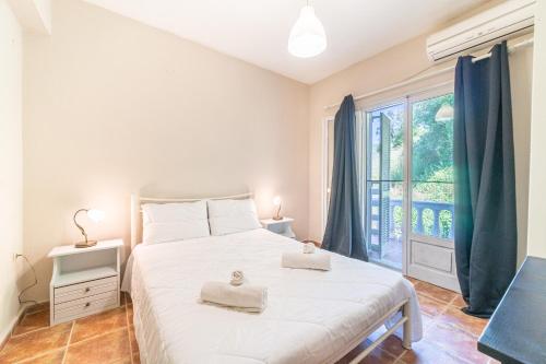 1 dormitorio con 1 cama blanca grande y toallas. en Agia Sana house Gardenos, en Vitalades