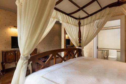 a bedroom with a large bed with a canopy at The Westbury Palace in Nuwara Eliya