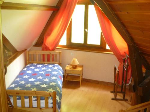 ein Schlafzimmer mit einem Bett im Dachgeschoss in der Unterkunft Le coin de paradis 