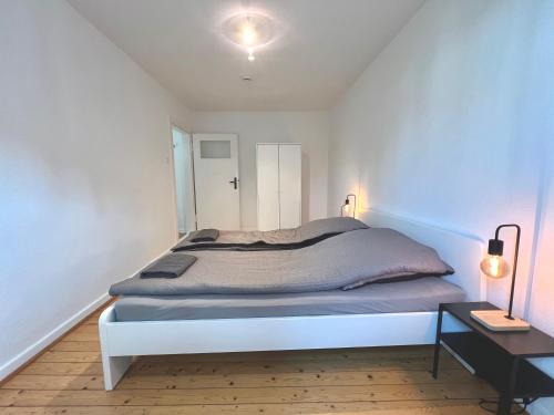 1 dormitorio con cama blanca y mesa en Doppelbett Unterkunft Vahrenwald-List en Hannover