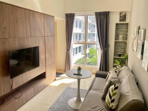 a living room with a couch and a tv and a table at Cosy 2 Bedder Near KLCC I 500mbps Wi-Fi I Smart TV with Netflix Function in Kuala Lumpur