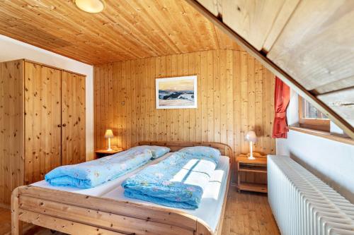 een slaapkamer met een bed in een houten kamer bij Landhaus Graf in Kniebis