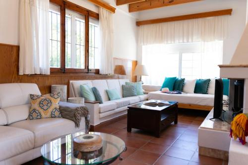 un soggiorno con divani bianchi e TV di Can Pep a Ibiza Città