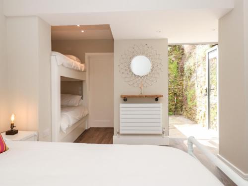 a bedroom with a bunk bed and a mirror at 44 Above Town in Dartmouth