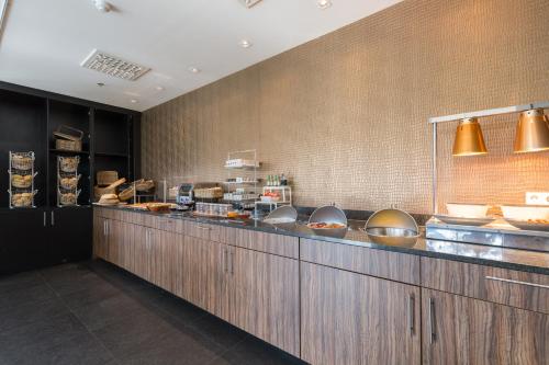 a kitchen with a bunch of food on the counter at Leonardo Royal Hotel Den Haag Promenade in The Hague