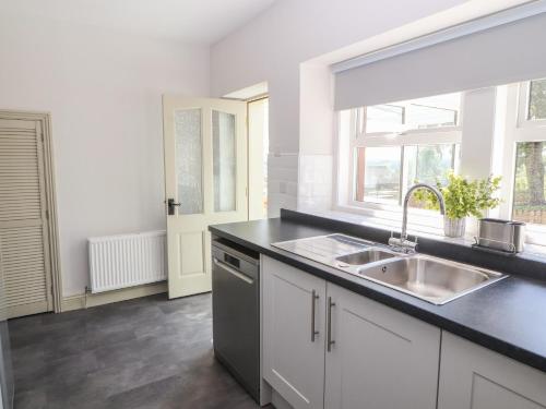 a kitchen with a sink and a window at Rose Bank Cottage in Carlisle