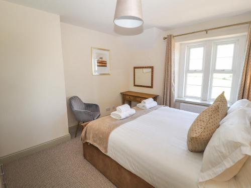 a bedroom with a large bed and a window at Rose Bank Cottage in Carlisle