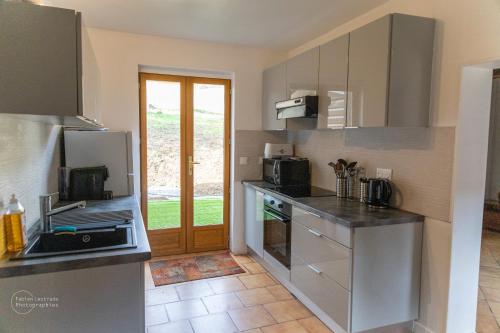 a kitchen with stainless steel appliances and a door at Le Domaine de la Désirée in Lisieux