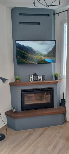 a living room with a fireplace with a flat screen tv at Seaview Luxury Apartment with private parking in Mytilini