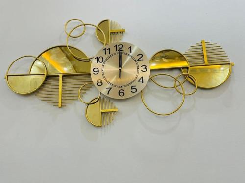 eine goldene und weiße Uhr an einer weißen Wand in der Unterkunft Appartement T 2 N 1: Résidence LES 11 PLURIELLES 