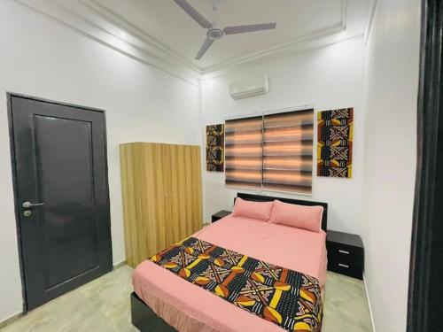 Schlafzimmer mit einem Bett mit rosa Bettwäsche und einer schwarzen Tür in der Unterkunft Appartement T 2 N 1: Résidence LES 11 PLURIELLES 