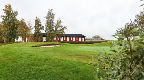 a view of a golf green with a building in the background at Bedinge Golfklubb hotell in Beddinge Strand