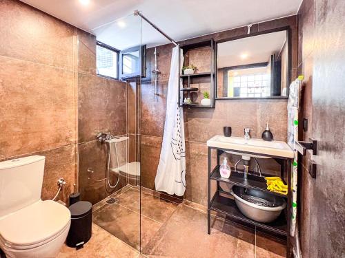 y baño con ducha, aseo y lavamanos. en Mini Loft Apartment, en Kalamata