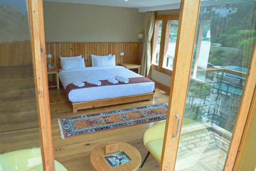 a bedroom with a bed and a glass door at Cholay Khangzang in Thimphu