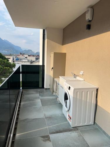 eine Waschmaschine und einen Trockner auf dem Balkon eines Gebäudes in der Unterkunft Garden Inn - Riva del Garda in Riva del Garda