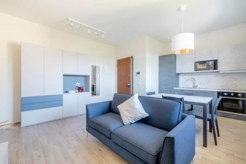uma sala de estar com um sofá azul e uma cozinha em Appartamento Michelangelo em Prato