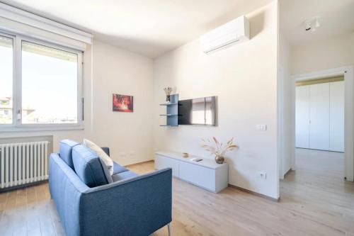 ein Wohnzimmer mit einem blauen Stuhl und einem Tisch in der Unterkunft Appartamento Michelangelo in Prato