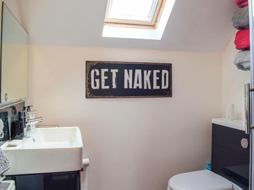 a bathroom with a toilet and a sign that says get made at The Studio in Dinmore