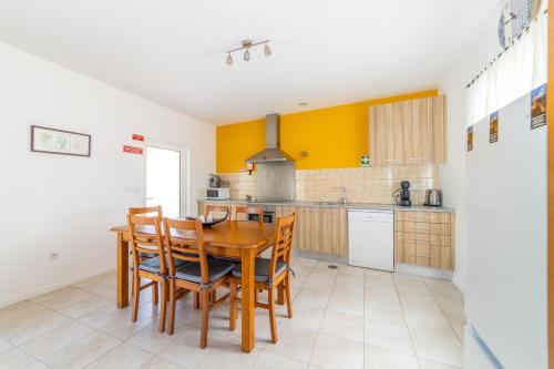 a kitchen with a wooden table and chairs at Casa do Sobreiro in Cantanhede