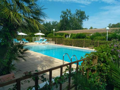 a swimming pool in a yard with a fence at Le Râteau Bavoir in Calvi