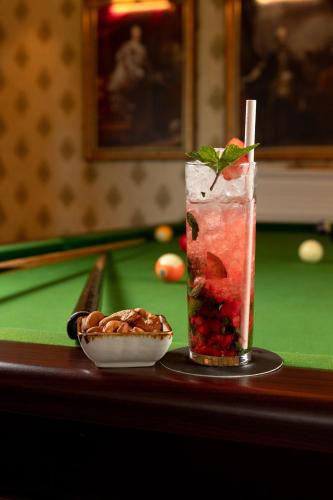 a drink on a pool table next to a bowl of fruit at The Westbury Palace in Nuwara Eliya