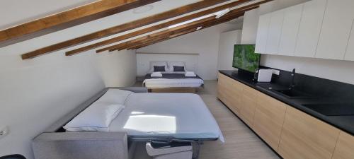 a bedroom with two beds and a sink and a tv at Dea Del Mar Apartments in Izola