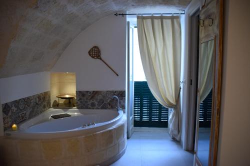 uma grande banheira numa casa de banho com uma janela em Nene' em Fasano
