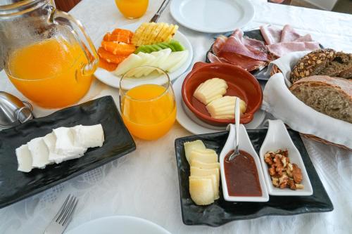 a table topped with plates of cheese and other foods at Rito Hall da Serra in Leiria