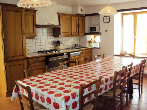 eine Küche mit einem Tisch mit einem roten und weißen Tischtuch in der Unterkunft Chez laure 