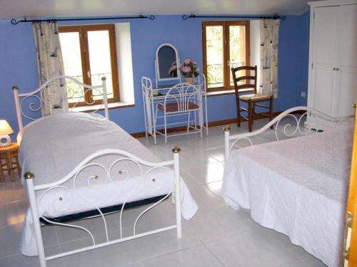 een slaapkamer met 2 bedden en een blauwe muur bij Chez laure 