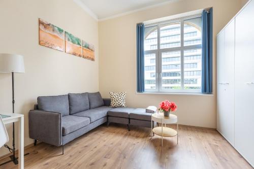 - un salon avec un canapé et une fenêtre dans l'établissement Mezzanine Apartments long-term, à Budapest