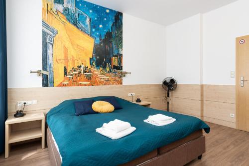 Un dormitorio con una cama azul con una pintura en la pared en Matejki-Kawowy en Poznan