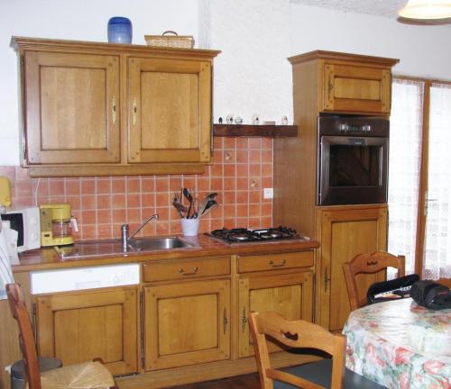 a kitchen with wooden cabinets and a sink at Casa bianca in La Horgne