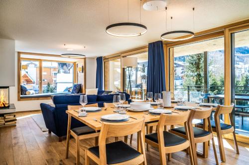 a dining room with a table and chairs and a couch at Riverside 2nd Floor South in Saas-Fee