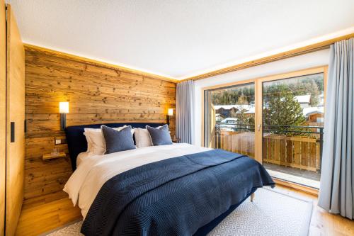 a bedroom with a bed and a large window at Riverside 2nd Floor South in Saas-Fee