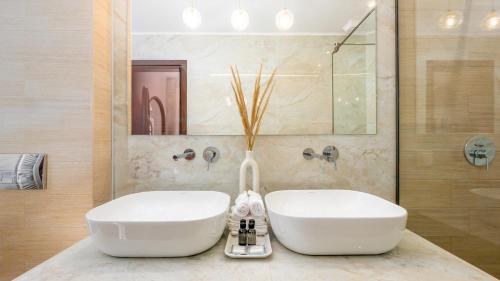 a bathroom with two white sinks on a counter at Pamina Mare in Nea Skioni