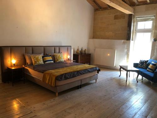 Clos de Bertinat في Saint-Sulpice-de-Faleyrens: غرفة نوم بسرير كبير مع أرضية خشبية