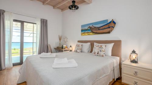 a bedroom with a bed with a view of the ocean at Pamina Mare in Nea Skioni