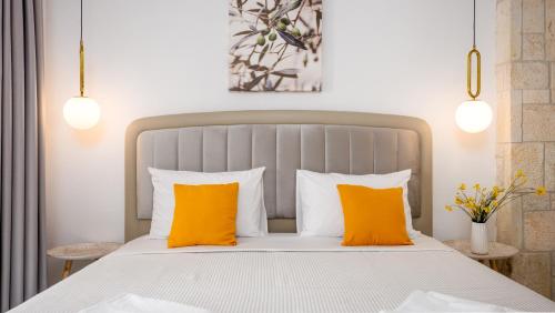 a bedroom with a bed with two orange pillows at Pamina Mare in Nea Skioni