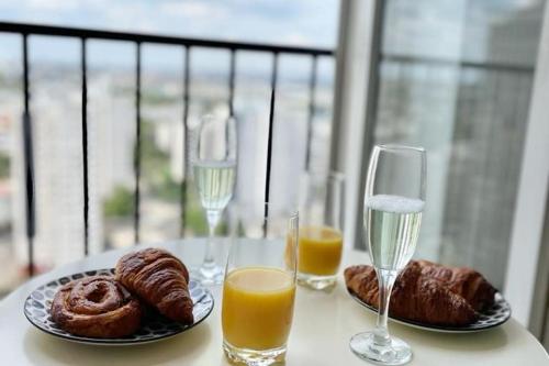 - une table avec deux verres de jus d'orange et des viennoiseries dans l'établissement Ciel de Paris : Vue Tour Eiffel, à Choisy-le-Roi