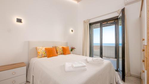 a bedroom with a bed with a view of the ocean at Pamina Mare in Nea Skioni