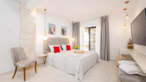 a white bedroom with a bed and a chair at Pamina Mare in Nea Skioni